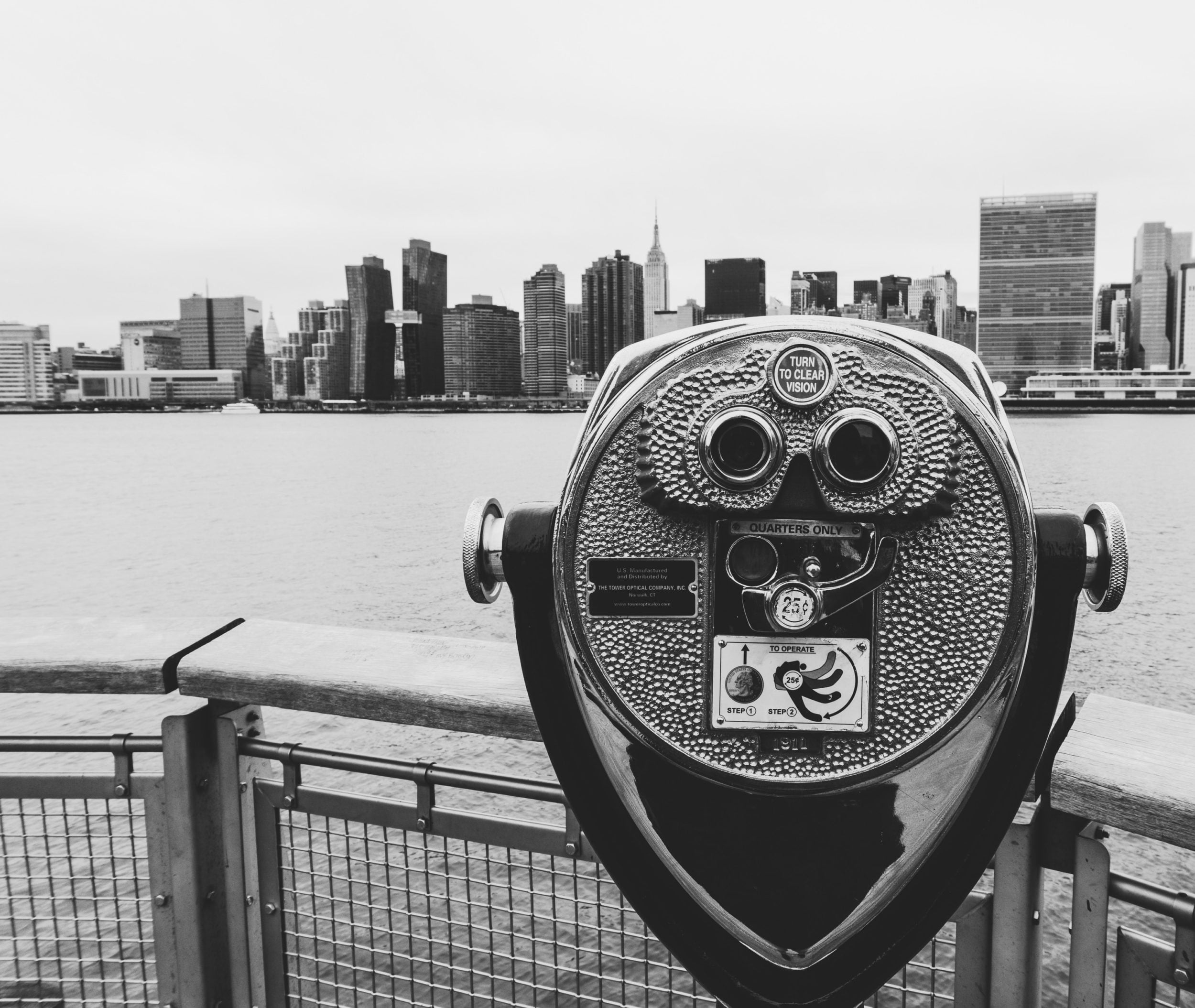a metal object with a face on it by a body of water