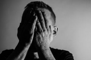 a man covering his face with his hands