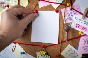 a hand holding a white piece of paper