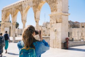 a person taking a picture of a large stone structure