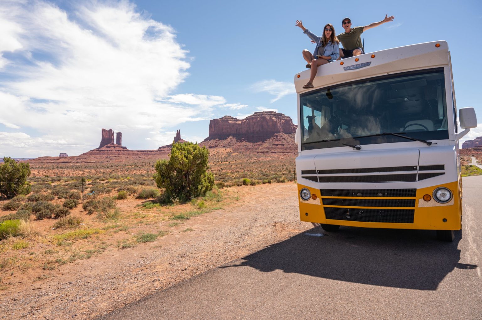 a couple of men on top of a bus