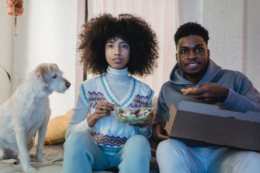 a man and woman sitting next to a dog