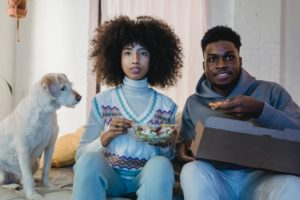a man and woman sitting next to a dog