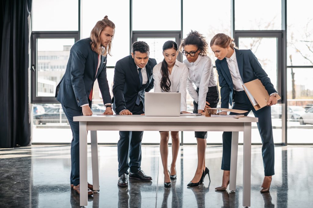 a group of people standing around a table