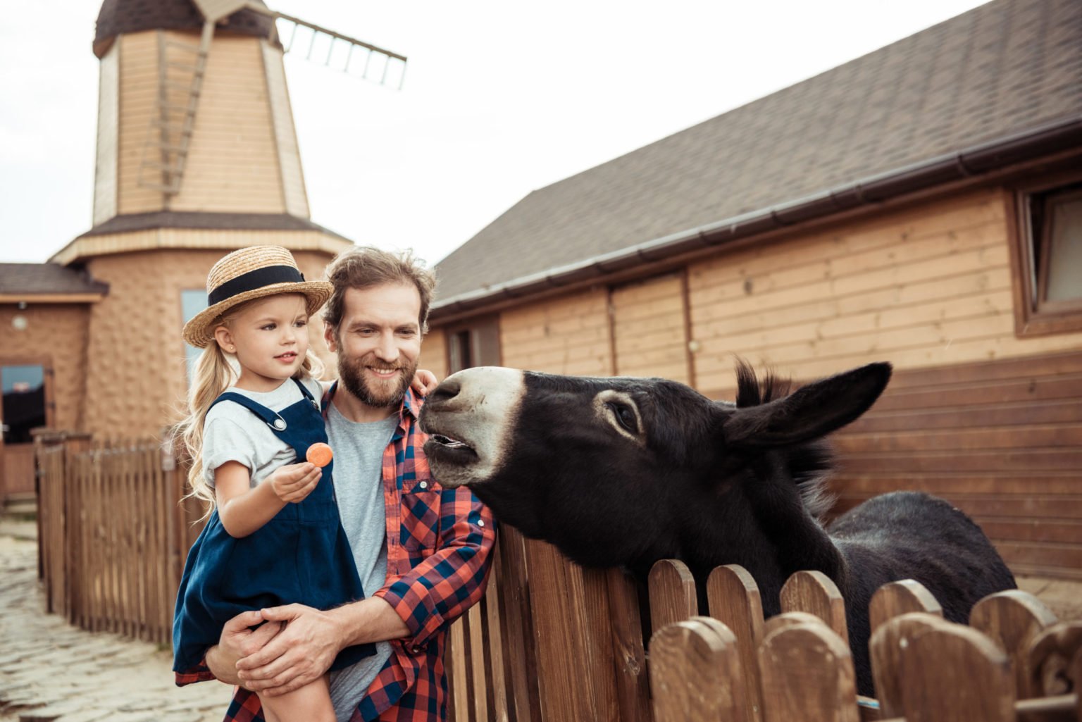 a person and a child holding a baby next to a horse